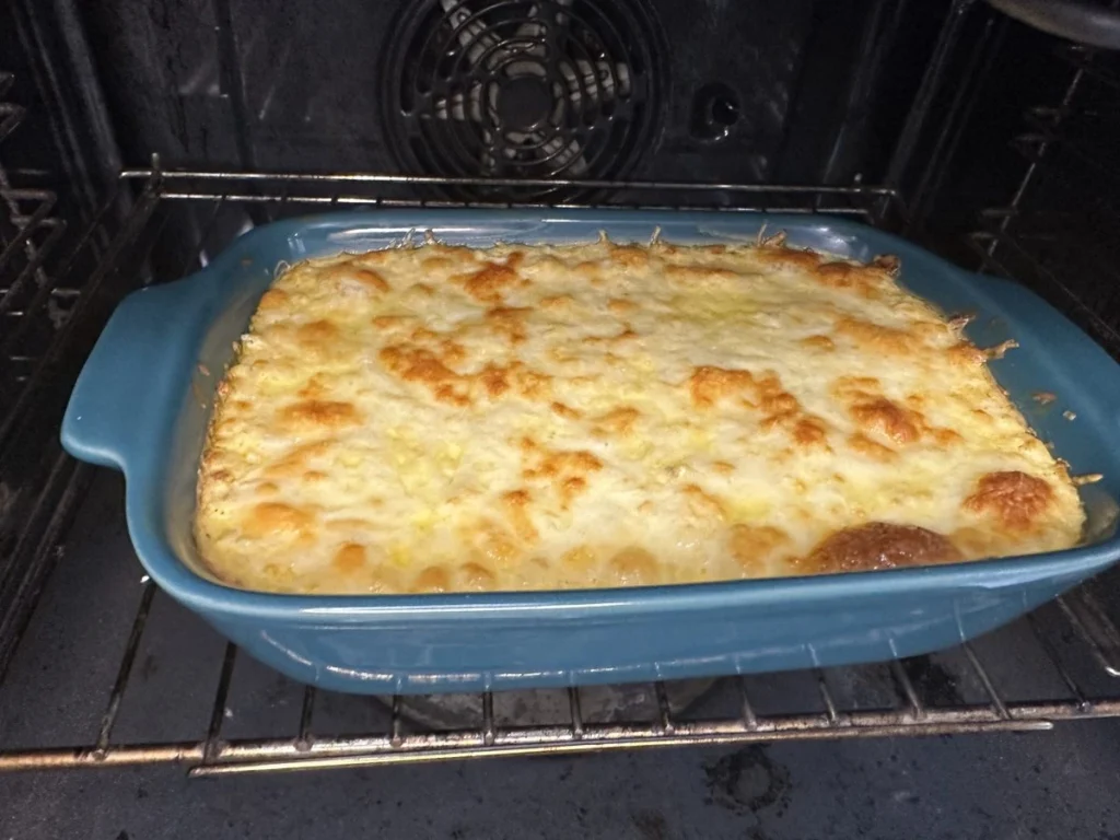 Buffalo chicken dip baking in the oven with melted cheese and golden browned spots
